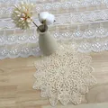 Detailed view of the intricate floral embroidery on a beige vintage lace doily - 15cm / Poppy Style