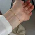 Close-up of dainty s925 silver four-leaf clover bracelet with sparkling crystals - 925 Silver / Gold