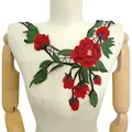 Gros plan d'une application de dentelle brodée fleurie rouge et verte sur un mannequin - Rouge