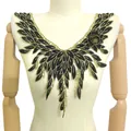 Gros plan d'un col en dentelle brodée noir et or sur un mannequin détail - Noir & Or