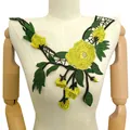 Détail de l'applique de col en dentelle brodée de fleurs jaunes et vertes sur buste - Jaune