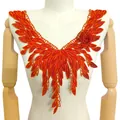 Détail d'un col en dentelle orange brodé avec rose 3D et motifs de feuilles sur un mannequin. - Orange