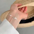 Macro detail view of a delicate s925 silver chain bracelet with a butterfly charm and white pearl - Butterfly Pearl Style (B6141) / Silver