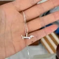 Detailed view of a cute 925 sterling silver dachshund pendant necklace held in a hand - Dachshund Shape Necklace (N1413)