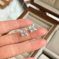 Vista detallada de pendientes de plata S925 con diseño de encaje y piedra verde central - Pendientes de Botón de Estrella con Piedra Verde (E8463)