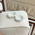 Detailed close-up of silver geometric faceted hoop earrings on a velvet display stand - Geometric Faceted Hoop Earrings (E8465)