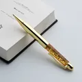 Detailed shot of a gold metal ballpoint pen with sparkling sequins on a white book. - Golden Sands