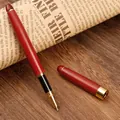 Vintage rosewood rollerball pen with gold trim on a classic wooden desk background - 0.5mm / Rosewood