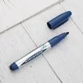 Professional blue permanent oil-based marker pen with wide fiber tip on wood surface. - Blue