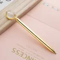 Elegant golden metal ballpoint pen with a crystal globe top placed on pink background - 1.0mm Black Ink / Gold