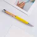 Elegant yellow metal ballpoint pen filled with sparkling gold crystals and shards - Yellow