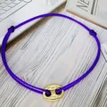 Close-up of a purple adjustable string bracelet featuring a gold pig nose charm - Pig Nose Woven Bracelet / Purple-Gold Plated