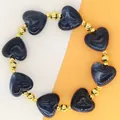Gedetailleerde weergave van de marineblauwe hartkralen en de gouden kraaltjes - Donkerblauwe Armband