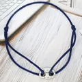 Detailed shot of a blue adjustable cord bracelet with a silver pig nose charm - Pig Nose Woven Bracelet / Dark Blue-Silver Plated