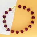 Detailed view of burgundy resin heart beads and gold beads on a choker necklace. - Dark Red Necklace