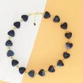 Close-up detail of a French style dark blue resin heart bead necklace with gold metal accents. - Dark Blue Necklace
