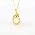 Close-up of golden oval locket necklace with white enamel center piece detail - White Enamel Oval Locket