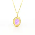 Close-up view of a golden oval locket pendant featuring a swirling purple enamel center. - Purple Enamel Oval Locket