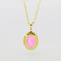 Close-up detail of a gold-plated oval locket pendant with swirling pink enamel inlay - Pink Enamel Oval Locket