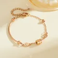 Detail eines roségoldenen Titanstahlarmbands mit zylindrischem Anhänger und Kettengliedern - Römisches Zylinderarmband (B318) / Roségold