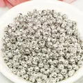 Macro shot of silver diamond-cut textured metal spacer beads for DIY jewelry making - 2.5mm / White Gold