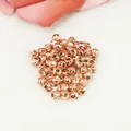 Close-up of faceted rose gold spacer beads with shiny textured surface for jewelry making - 2.5mm / Rose Gold