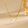 Detailansicht einer eleganten doppellagigen Goldkette mit Perlenanhänger im Fokus - Gold Perle Klinge Runde Schlange Halskette (D705) / Gold