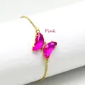 Nahaufnahme eines rosa Kristall-Schmetterlingsanhängers an einer goldenen Schlangenkette - Rosa