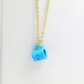 Detailed close-up of a creative blue coffee cup pendant necklace with a fine gold chain - Sky Blue