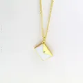 Detailed macro shot of a gold-plated envelope necklace with white enamel and a tiny crystal. - Envelope Bag Style