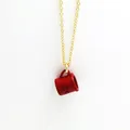 Detailed close-up view of a creative red enamel coffee mug pendant on a gold chain. - Red