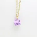 Detailed shot of creative purple enamel coffee cup pendant on a minimalist gold chain - Purple
