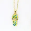 Macro detail of a gold slipper pendant featuring blue evil eye motifs and sparkling stones. - Yellow