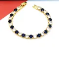 Detailansicht eines goldfarbenen Tennisarmbands mit blauen und klaren Zirkonia-Steinen. - Gold Blau-Weißer Stein Stil / Gold