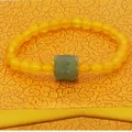 Detailed view of the handcrafted jade tiger charm on an orange agate beaded bracelet. - Agate