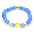 Detailed shot of a blue cat's eye stone bracelet featuring a cute golden dragon charm - Cat-eye Stone Bracelet / Light Blue