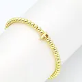Nahaufnahme eines 18K vergoldeten Perlenarmbands mit einem 3D-Großbuchstaben F. - Buchstabe F
