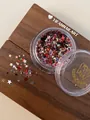 Macro detail view of colorful mixed star-shaped nail art glitter sequins in a jar - Dark Color Mixed