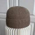 Detailopname van de hoogwaardige bruine geribbelde gebreide muts op witte papieren standaard - M (56-58cm) / Donker kaki