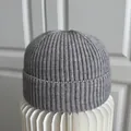 Gedetailleerde weergave van een grijze ribgebreide muts op een witte standaard - M (56-58cm) / Grijs
