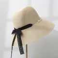 Detailed side view of a women's straw sun hat featuring elegant black lace bow and pearl chain - M (55-57.5) / Beige