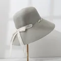 Detailed side view of a grey wide-brim straw sun hat with lace bow and pearl trim - M (55-57.5) / Gray