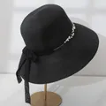 Detail view of elegant black wide-brim straw hat with pearl trim and lace bow - M (55-57.5) / Black
