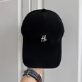 Detalle de una gorra de béisbol retro negra de alta calidad con bordado de letras H& blancas - Ajustable (56-58cm) / Estilo Letra H& / Negro