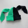Close-up detail of the vibrant green and black split color knitted bunny ear beanie - M (56-59cm) / Green & Black