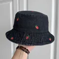 Detailed view of the black denim bucket hat featuring vibrant red strawberry embroidery - Black Small Strawberry
