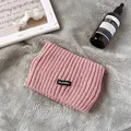 Detailansicht eines rosa gestrickten Thermo-Stirnbandes mit Etikett - Rosa