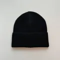 Detailed view of a soft black knitted beanie with a classic ribbed cuff design - One Size / Black