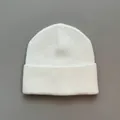 Detailed macro view of the soft white knitted texture of a winter beanie hat - One Size / White