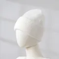Detailansicht einer weichen weißen Strickmütze aus Kaninchenhaar für Damen im Profil. - Weiß